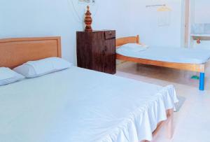 - une chambre avec 2 lits et une armoire en bois dans l'établissement Erojo's Beach Resort, à Sindangan