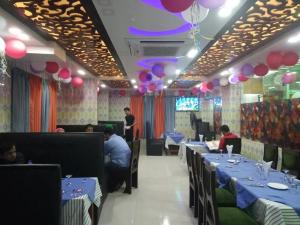 a restaurant with tables with people sitting at them at Shopnonir Hotel & Restaurant in Chittagong