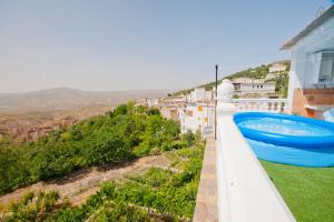 a blue swimming pool on the side of a house at Casa Mamica Rosario in Yegen