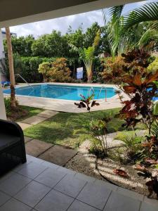 a swimming pool in the middle of a yard at Amaryl The Dream St Lawrence Gap 2BR condo with pool in Christ Church