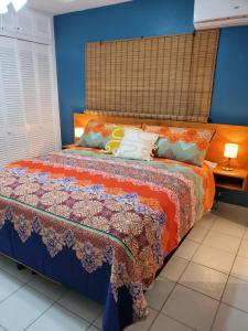 a bedroom with a bed with a colorful blanket at Amaryl The Dream St Lawrence Gap 2BR condo with pool in Christ Church