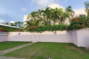 a white fence with plants on the side of a house at Amaryl The Dream St Lawrence Gap 2BR condo with pool in Christ Church