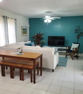 a living room with a white couch and a table at Amaryl The Dream St Lawrence Gap 2BR condo with pool in Christ Church