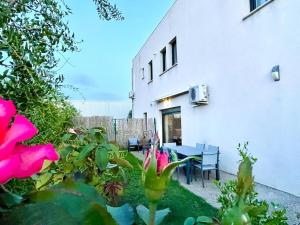 un jardin avec des fleurs roses et une table ainsi qu'un bâtiment dans l'établissement Vacances dans le Sud de la France, à Istres