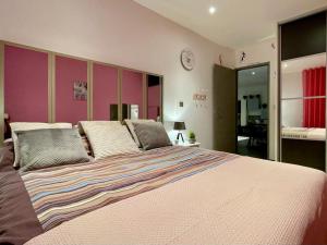 - une chambre avec un grand lit aux murs roses dans l'établissement Vacances dans le Sud de la France, à Istres