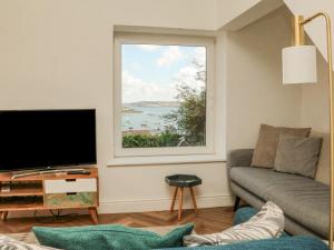 a living room with a large window and a couch at Through The Porthole in Falmouth