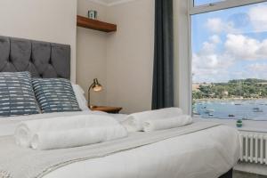 a bedroom with a bed with a large window at Through The Porthole in Falmouth