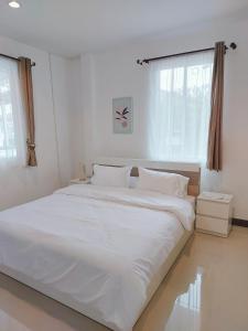 a large white bed in a white room with a window at HAPPY SPACE วิลล่าทั้งหลัง 2นอน 2น้ำ ฟรี Wifi จอดรถ in Nakhon Phanom