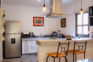 a kitchen with two chairs sitting at a counter at BELLAS VILLAS, VILLA AMOR HERMOSA CASA a UN ACCECIBLE PRECIO in San Miguel de Allende