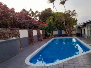 een blauw zwembad in een tuin met bomen bij Blue Lantern Ramsgate in Margate