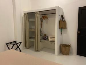 Chalisa Villas Koh Tao في كو تاو: غرفة نوم مع خزانة مع مرآة وسرير
