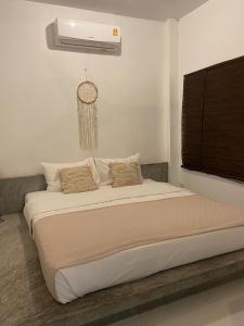 a bedroom with a large bed with a air conditioner at Chalisa Villas Koh Tao in Ko Tao