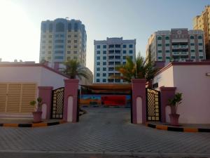 une porte au milieu d'une ville avec de grands bâtiments dans l'établissement Oasis Hotel Apartment, à Ras al Khaimah