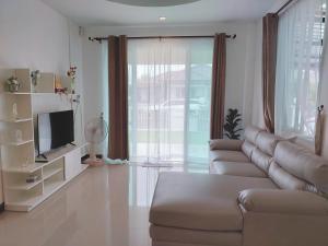 ein Wohnzimmer mit einem Sofa und einem TV in der Unterkunft HAPPY SPACE วิลล่าทั้งหลัง 2นอน 2น้ำ ฟรี Wifi จอดรถ in Nakhon Phanom