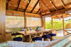 a wooden table and chairs in a pavilion at New Sunny Villa With Pool Metro Country Club Juan Dolio in La Puntica de Juan Dolio