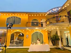 ハノイにあるRubic Home Ba Vi - Venuestayの家の前のテーブルに座る女