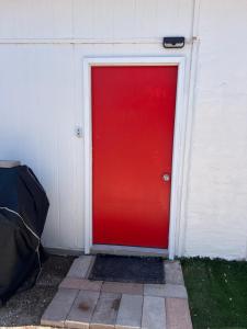 uma porta vermelha do lado de um edifício em Tiny Home em El Paso