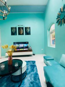 ハノイにあるRubic Home Ba Vi - Venuestayの青いリビングルーム(ソファ、テーブル付)