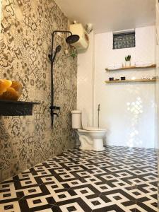 a bathroom with a toilet and a black and white floor at Thênh Thang Home & Cafe in Mộc Châu