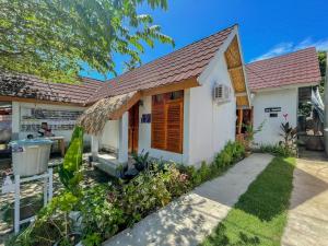 a white house with a brown roof at Aira Homestay near Pantai Kuta Mandalika Mitra RedDoorz in Bumbang
