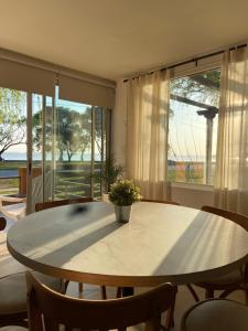 - une table et des chaises dans une chambre avec fenêtre dans l'établissement Casa Chalet "La Roja" -vista a la laguna!!!-, à Chascomús
