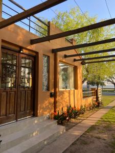ein Haus mit einer Eingangstür und einer Veranda in der Unterkunft Casa Chalet "La Roja" -vista a la laguna!!!- in Chascomús