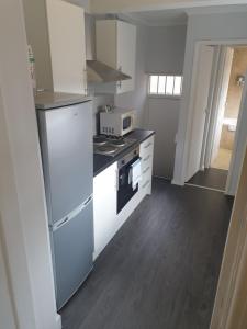 a kitchen with a stove and a microwave at Gateshead's Amethyst 3 Bedroom Apt, Sleeps 6 Guests in Gateshead