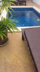 a pool with a bench next to a potted plant at Chalisa Villas Koh Tao in Koh Tao