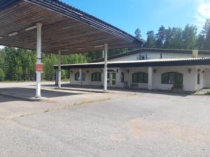 an empty gas station with a large building at Jaalan Tienristi in Kouvola