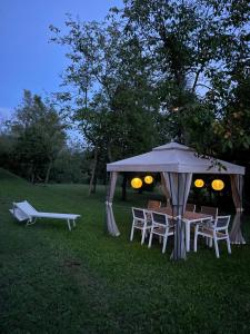 a table and chairs under a tent in the grass at B&B I Falchi Pellegrini in Monzuno