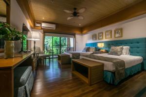 a hotel room with two beds and a television at Istorya Forest Garden Resort 