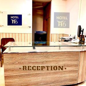 a hotel reception desk with a sign that reads reception at Hotel H6 in Rawalpindi