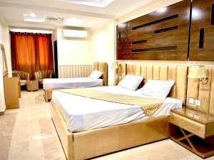 una habitación de hotel con 2 camas en una habitación en Hotel H6, en Rawalpindi