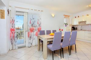 una cucina e una sala da pranzo con tavolo e sedie viola di Apartments with a parking space Podstrana, Split - 17053 a Podstrana
