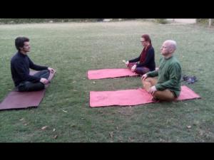 un groupe de trois personnes assises sur des tapis dans l'herbe dans l'établissement Ranakpur Nature Retreat, à Sādri