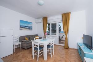 a living room with a table and a couch at Apartments by the sea Novalja, Pag - 17214 in Novalja