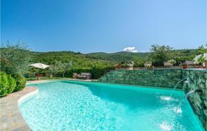 a swimming pool with a stone wall next to at Villamota in Arezzo