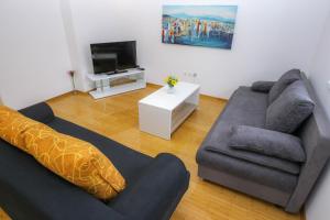 sala de estar con sofá y TV en Apartments with a parking space Novalja, Pag - 17364, en Novalja