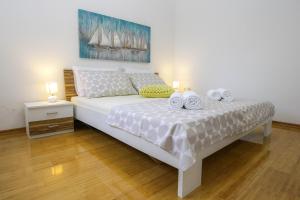 1 dormitorio con 1 cama blanca grande con 2 velas en Apartments with a parking space Novalja, Pag - 17364, en Novalja