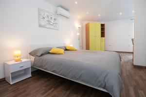 - une chambre avec un grand lit et un oreiller jaune dans l'établissement Apartments with a parking space Liganj, Opatija - 17370, à Lovran
