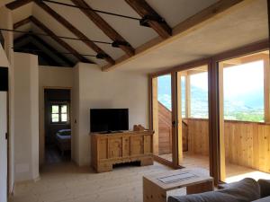 sala de estar con TV de pantalla plana y ventanas en hoamisch en Malles Venosta