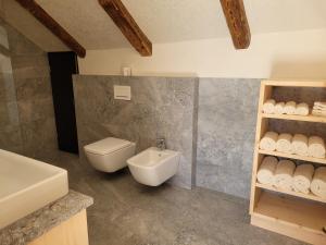 y baño con aseo blanco y lavamanos. en hoamisch en Malles Venosta