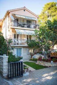 an apartment building with a balcony and a yard at Apartments by the sea Petrcane, Zadar - 17179 in Petrcane