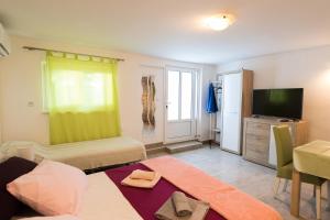 a bedroom with a bed and a tv and a room at Apartments by the sea Petrcane, Zadar - 17179 in Petrcane