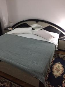 a bed with a green blanket and white pillows at Apartments with a parking space Brela, Makarska - 17371 in Brela