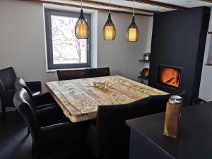 a dining room with a table and chairs and a fireplace at Romantic standalone 5 room cottage in Valposchiavo in Poschiavo