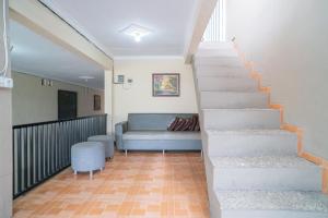 ein Wohnzimmer mit einer Treppe und einer Couch in der Unterkunft RedDoorz At Villa Akbar 3 in Batu