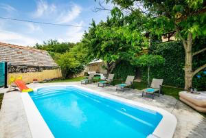 a swimming pool in the backyard of a house at Family friendly house with a swimming pool Vojnic Sinjski, Zagora - 17375 in Trilj