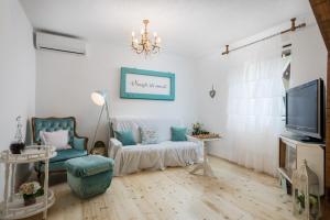 a living room with a chandelier and a tv at Family friendly house with a swimming pool Vojnic Sinjski, Zagora - 17375 in Trilj