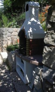 einem Backsteinofen auf einer Steinmauer in der Unterkunft Apartments by the sea Moscenicka Draga, Opatija - 17381 in Mošćenička Draga